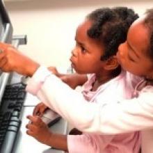 two young children using a computer